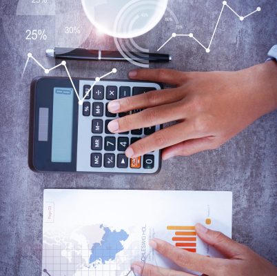 Person computing on calculator with financial analysis graphs. Woman working with diagram. Marketing concept. Cropped view.